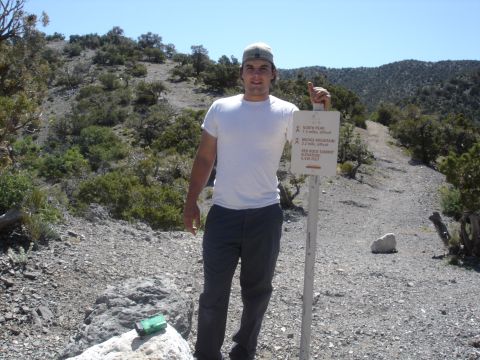 1996 Ford Bronco - A man poses for a photo next to a sign indicating trail distances and elevation in a mountainous area.