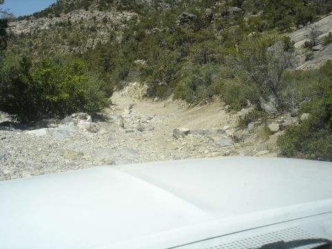 1996 Ford Bronco - View from inside a vehicle driving on a rough, rocky mountain trail.
