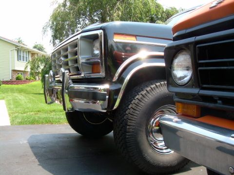 1984 Ford Bronco - A black 1978 Ford Bronco is parked next to another vehicle, showing its front end and chrome details.