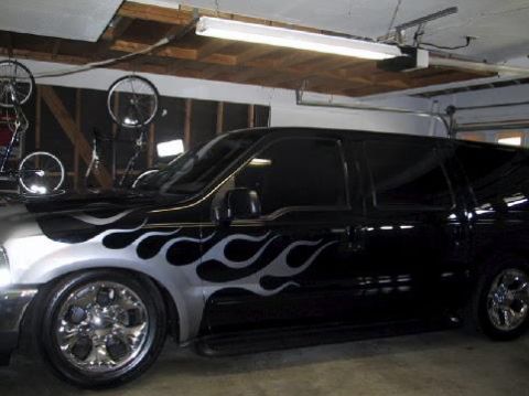 2001 Ford Excursion - This black SUV features prominent silver flame decals along its side and a 3/4 front view.