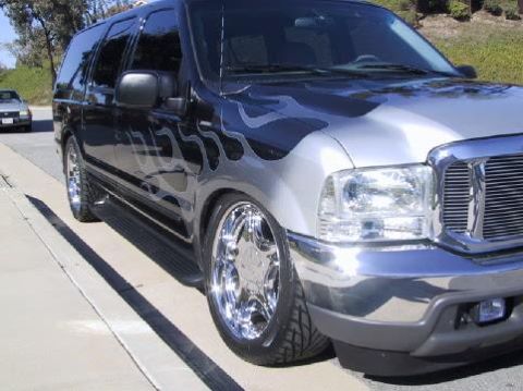 2001 Ford Excursion - This modified Ford Excursion features custom flame decals and large chrome wheels.