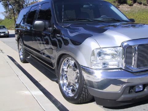 Black and silver full-size SUV with flame graphics and chrome wheels, front 3/4 view