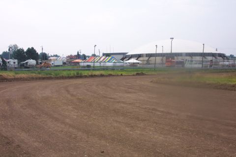 1978 Ford Bronco - A dirt track is in the foreground, with tents and a large domed building visible in the distance.