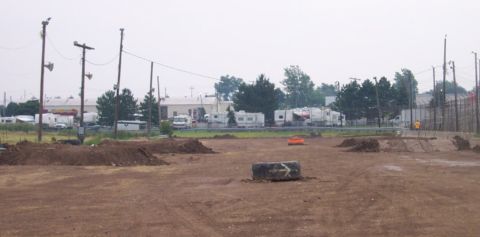 1978 Ford Bronco - A dirt track scene with RVs and buildings in the background, utility poles and obstacles.