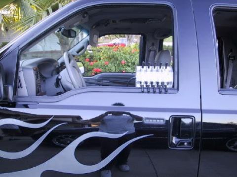 2001 Ford Excursion - This black SUV features white flame decals along its side and a visible interior with chrome accents.