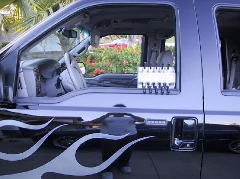 Silver SUV door with white tribal flames, gray interior and chrome-topped bottles inside