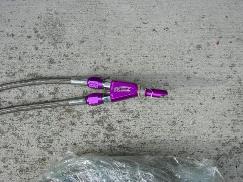 1996 Ford Probe - Close-up of purple fuel line fittings and braided hoses on a concrete surface.
