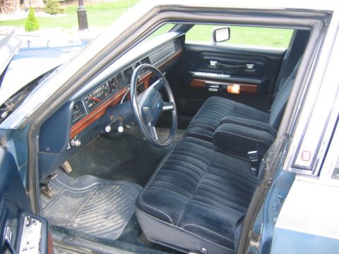 1988 Ford Crown Victoria LTD - Interior view of a sedan, a blue velour bench seat and wood-grain trim on the dashboard.