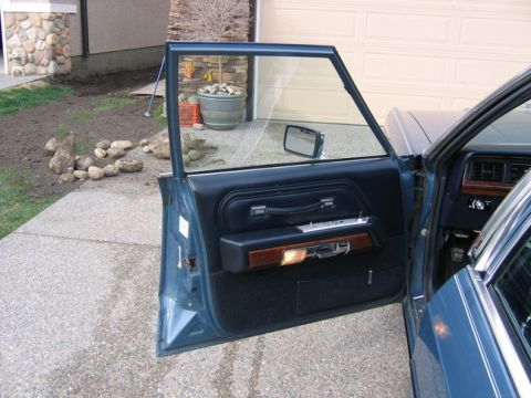 1988 Ford Crown Victoria LTD - Interior view of a blue sedan's door panel and dashboard, showing the wood trim and fabric details.