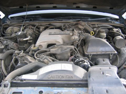 1988 Ford Crown Victoria LTD - The engine bay of a vehicle, with a "CAUTION FAN" label on the fan shroud.