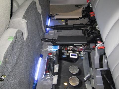 2001 Ford Excursion - Aftermarket amplifier and wiring are visible under the seats, along with blue LED lighting.