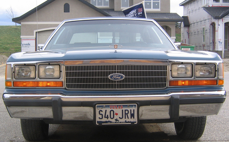 1988 Ford Crown Victoria LTD - The front grille and headlights of a 1988 Ford Crown Victoria LTD are visible, with a Texas license plate in place.