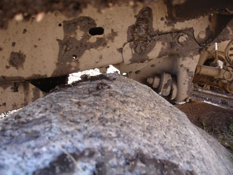 1984 Ford Bronco - Mud-caked frame and tire suggest off-road use.