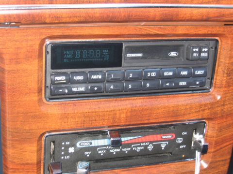 1988 Ford Crown Victoria LTD - The interior of a 1988 Ford Crown Victoria LTD features wood-grain trim surrounding the radio and climate controls.