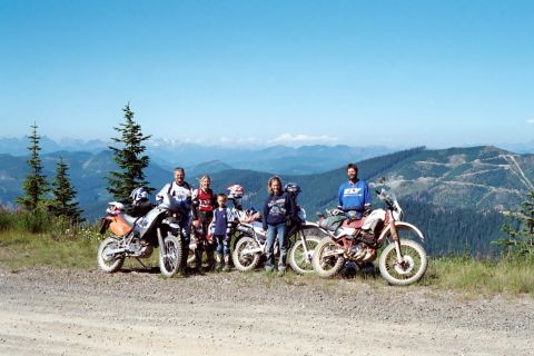 1997 BMW F650 - A group poses with their motorcycles against a scenic mountain backdrop, enjoying an outdoor adventure.