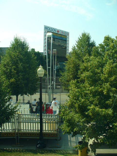1995 Ford Taurus - A large Jumbotron displays a race, with trees and spectators visible in the foreground.