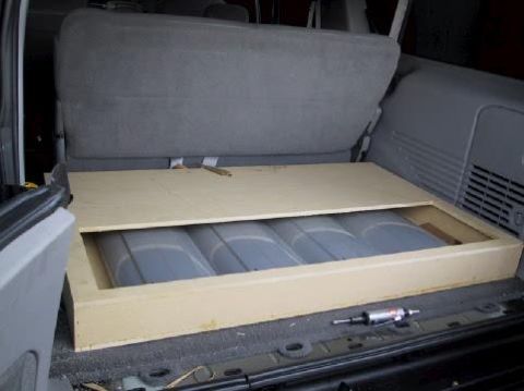 2001 Ford Excursion - Custom storage box installed in the cargo area of a 2001 Ford Excursion, covering fuel tanks.