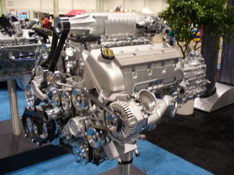1995 Ford Taurus - A V8 engine with a supercharger is on display at an auto show.