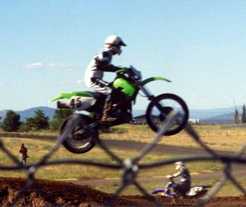 1997 BMW F650 - Dirt bike rider jumps during a motocross event, with another rider visible in the background.