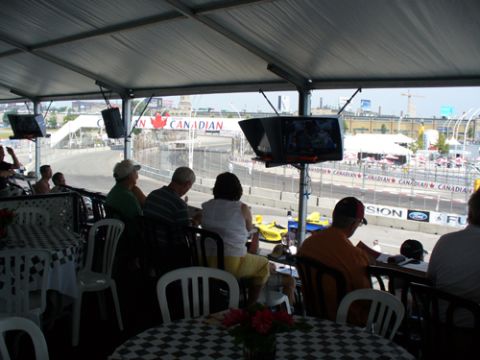 1995 Ford Taurus - View from the grandstand shows a race car on the track with spectators watching.