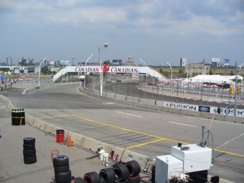 1995 Ford Taurus - A race track scene with a pedestrian bridge and tires staged near the track.