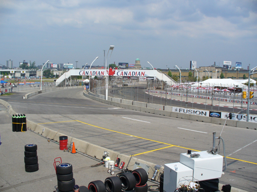 Race track with Canadian bridge overhead and stacks of tires on the side