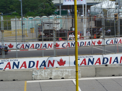Dark coupe on race track with Molson Canadian banners