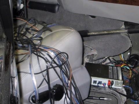 2001 Ford Excursion - A complex wiring setup and amplifier are visible inside the vehicle's interior, obscuring details of the car itself.