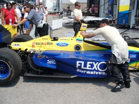 1995 Ford Taurus - A race car with "FLEXO abrasives" branding is being attended to by crew members in racing suits.
