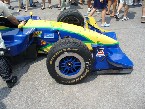 Blue and yellow open-wheel race car with Bridgestone tires and various sponsor decals