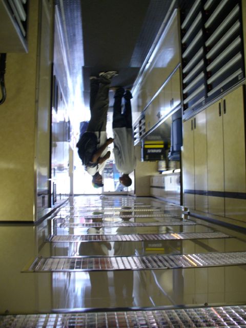 1995 Ford Taurus - Reflections of two people are visible in the polished floor of a workshop, surrounded by storage units.