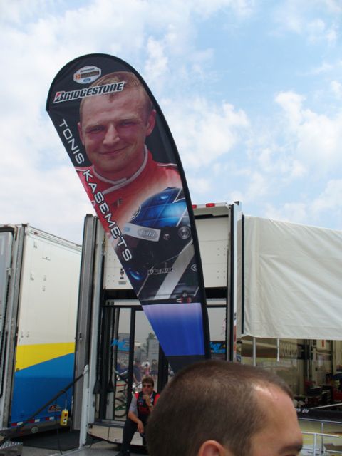 1995 Ford Taurus - A racing banner Tonis Kasemets is displayed near trailers at an event.