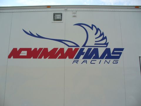 1995 Ford Taurus - Side view of a white trailer displaying the Newman Haas Racing logo and Supermotors.net branding.
