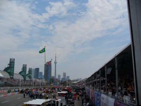 1995 Ford Taurus - A view of a race track with spectators and a city skyline in the background under a cloudy sky.