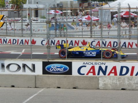 1995 Ford Taurus - A race car with "FLEXOVIT" branding speeds along the track, with Molson Canadian signage in the background.