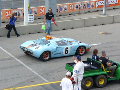 1995 Ford Taurus - A light blue Ford GT40 race car with orange stripes and the number 6 on its door is on a track.