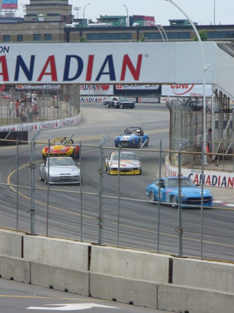 1995 Ford Taurus - Race cars compete on a track under a large "CANADIAN" banner.