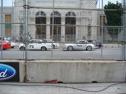 1995 Ford Taurus - A white race car with the number 160 is visible behind a fence, alongside other vehicles.