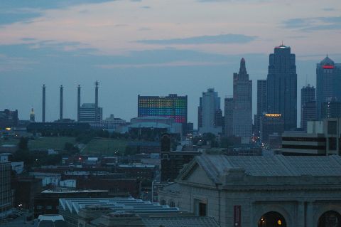 1998 Jeep TJ - A wide view of a city skyline at dusk, industrial smokestacks and illuminated buildings.