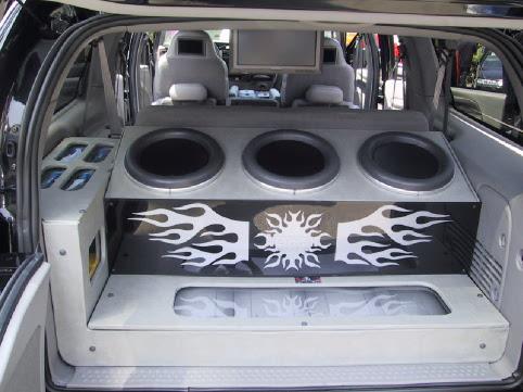 Custom triple-subwoofer install with flame graphics in SUV cargo area
