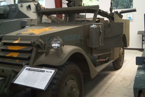 1966 Jeep CJ5 - This olive drab military half-track, marked with yellow stars and a serial number, is equipped with a machine gun.