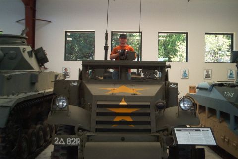 1966 Jeep CJ5 - An armored vehicle with a star insignia is displayed indoors, alongside other military vehicles and historical portraits.