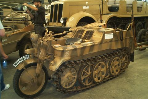 1966 Jeep CJ5 - A Kettenkrad half-track motorcycle is parked next to a larger military truck.