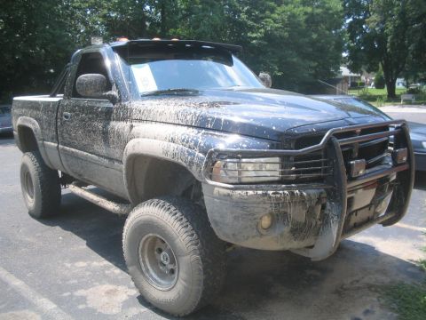 1990 Ford Bronco - This pickup truck is covered in mud, suggesting it has been off-roading.