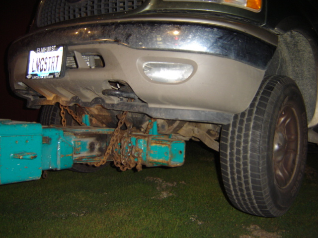 Front bumper and tow hitch assembly on a Ford truck, possibly from the early 2000s