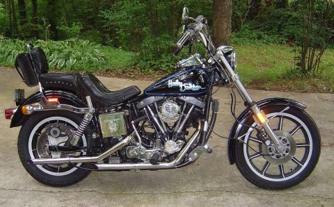 1986 Ford Bronco - A black Harley-Davidson motorcycle with a two-up seat and saddlebags is shown parked outdoors.
