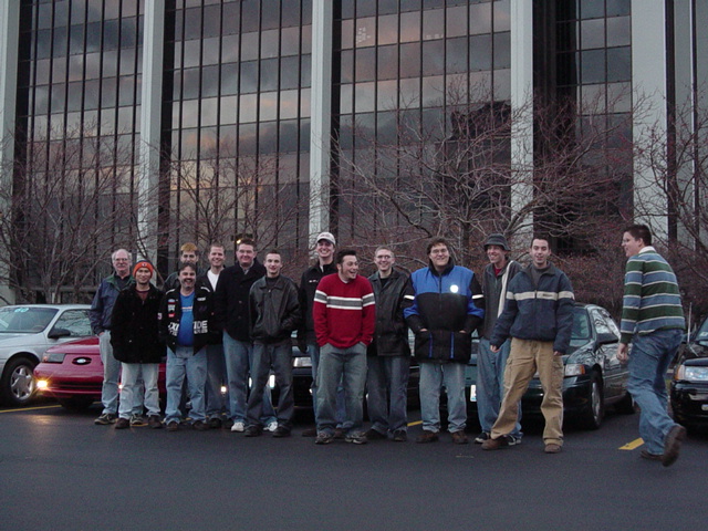 Group of men with cars, one red car visible