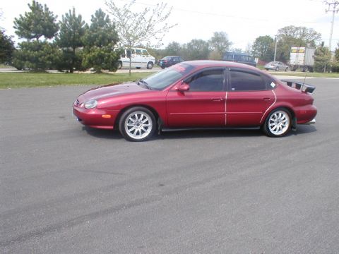 1998 Ford Taurus - This 1998 Ford Taurus is shown from the side, a spoiler and aftermarket wheels.