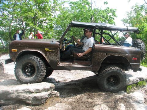 1992 Ford Bronco - Ford Bronco navigating rocky terrain with occupants inside.