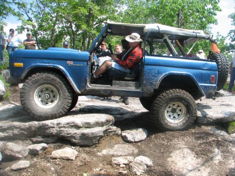 1992 Ford Bronco - This blue 1978 Ford Bronco is shown off-roading over large rocks.